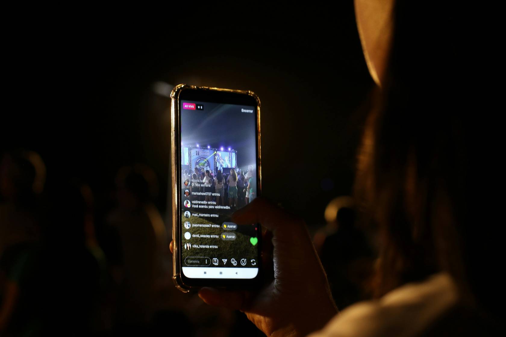 Person using a mobile phone for Instagram Live with text "AO VIVO" and various usernames joining the live stream.